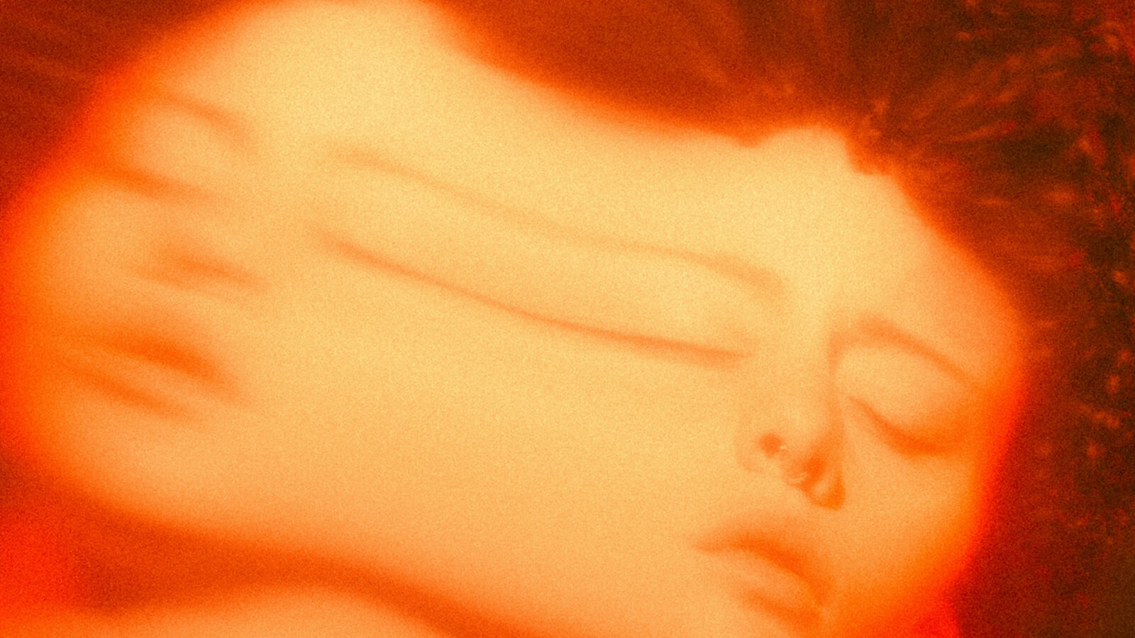 a blurred image of a young woman with her eyes closed